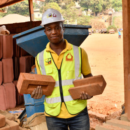 Eric Andela showing low-carbon bricks produced by the Keramos Cameroon, a small-scale enterprise making eco-construction materials and ceramics