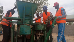 Brick makers using a mechanized brick press with high production capacity in Mora, Far North Cameroon.