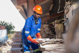 Artisanal and small-scale miner sorting flat stones for construction at a stone processing facility in Lusaka, Zambia