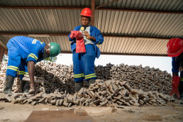Artisanal and small-scale miner sorting flat stones for construction at a stone processing facility in Lusaka, Zambia