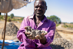 Artisanal and small-scale miner displaying mined and sized aggregates in Dambwa in Livingstone district Zambia