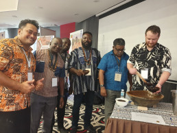 Exhibition participants at the Fiji stall, serving themselves kava, a traditional Fijian drink from a clay bowl made by potters in Fiji