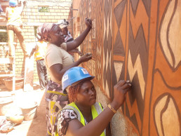 Tiébélé women applying the traditional mural painting on the ToT LCM demonstration building in Ouagadougou
