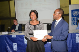 Certificate awarded by the Acting Minister of Mines, Prof. Fuh Calistus Gentry, to Ms. Christelle Ngah, Coordinator of the SDP/GYB Programme