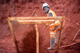 Sieving soil with a large screen to remove coarse material