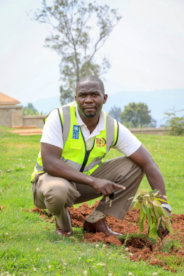 A participant showcases a newly planted tree, reflecting the training’s emphasis on environmental responsibility in the mining sector.