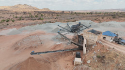 The primary crushing stage at STAMICO's facility, where granite is processed into valuable construction aggregates - the foundational step in the development of minerals value chain.