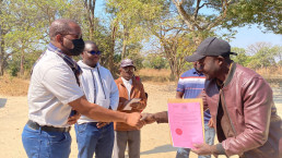 Government officials and programme staff assisting an artisanal and small-scale miner with completing a mining licence application form during a formalization mission in Livingstone, Zambia.
