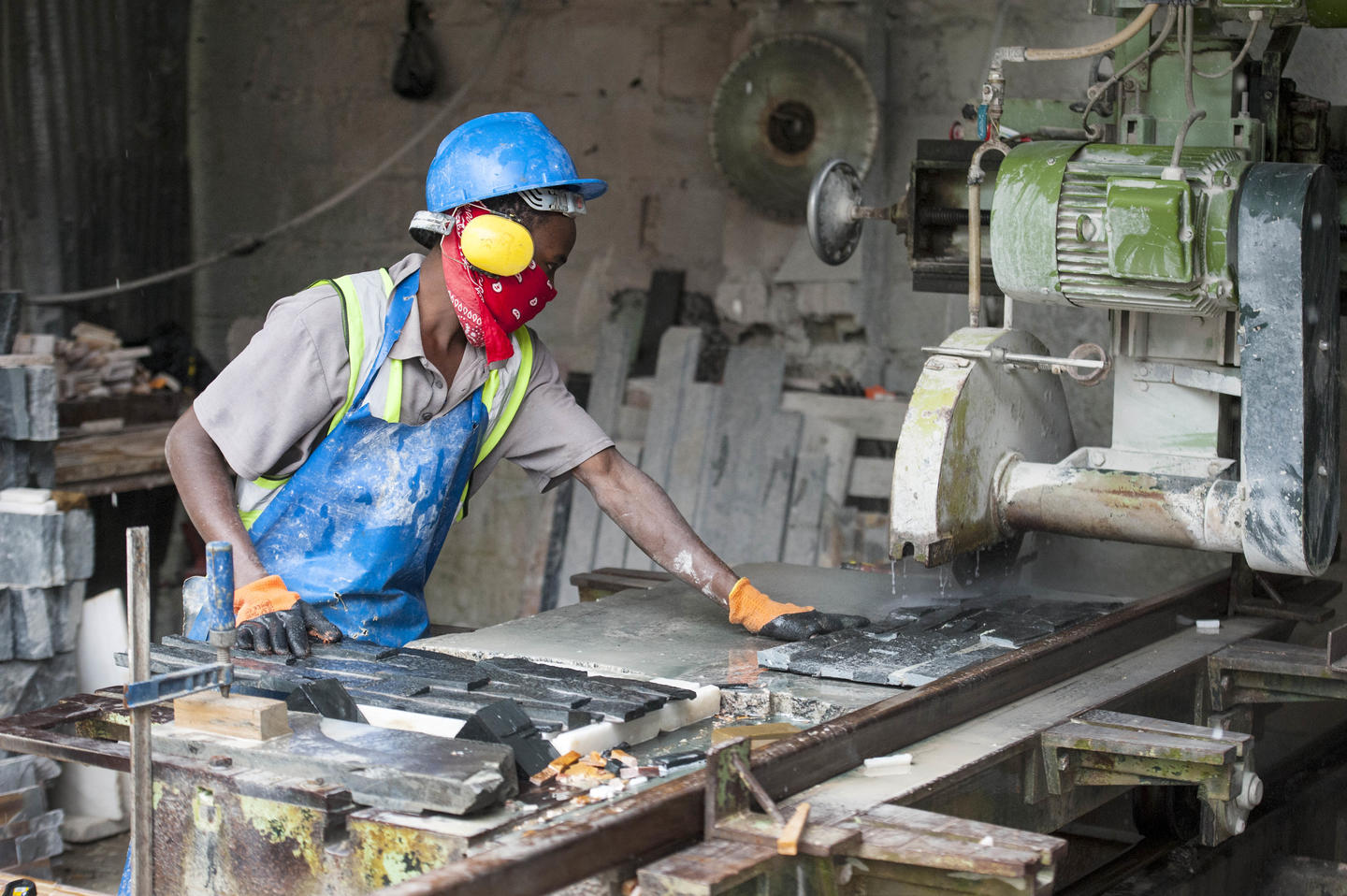 A stonecutter processing dimension stones into finished tiles
